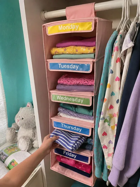 Child choosing a striped shirt from the pink Thursday cubby