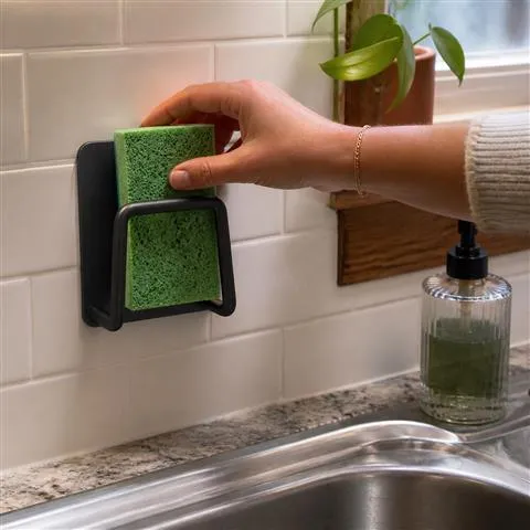 Black sponge holder on a white tile backsplash