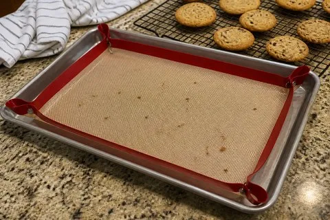 Red snap-corner baking mat after a batch of cookies