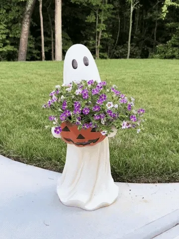 Ghost pumpkin bowl displayed with purple flowers outdoors