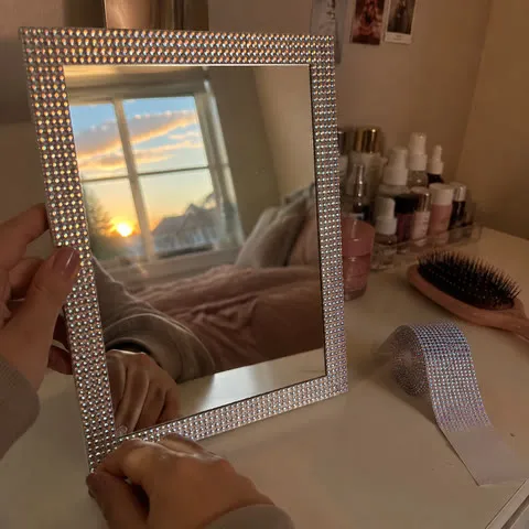 Iridescent rhinestone tape around a vanity mirror