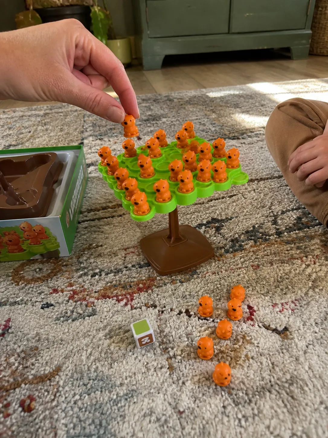 Family playing the capybara balance game on a living-room rug