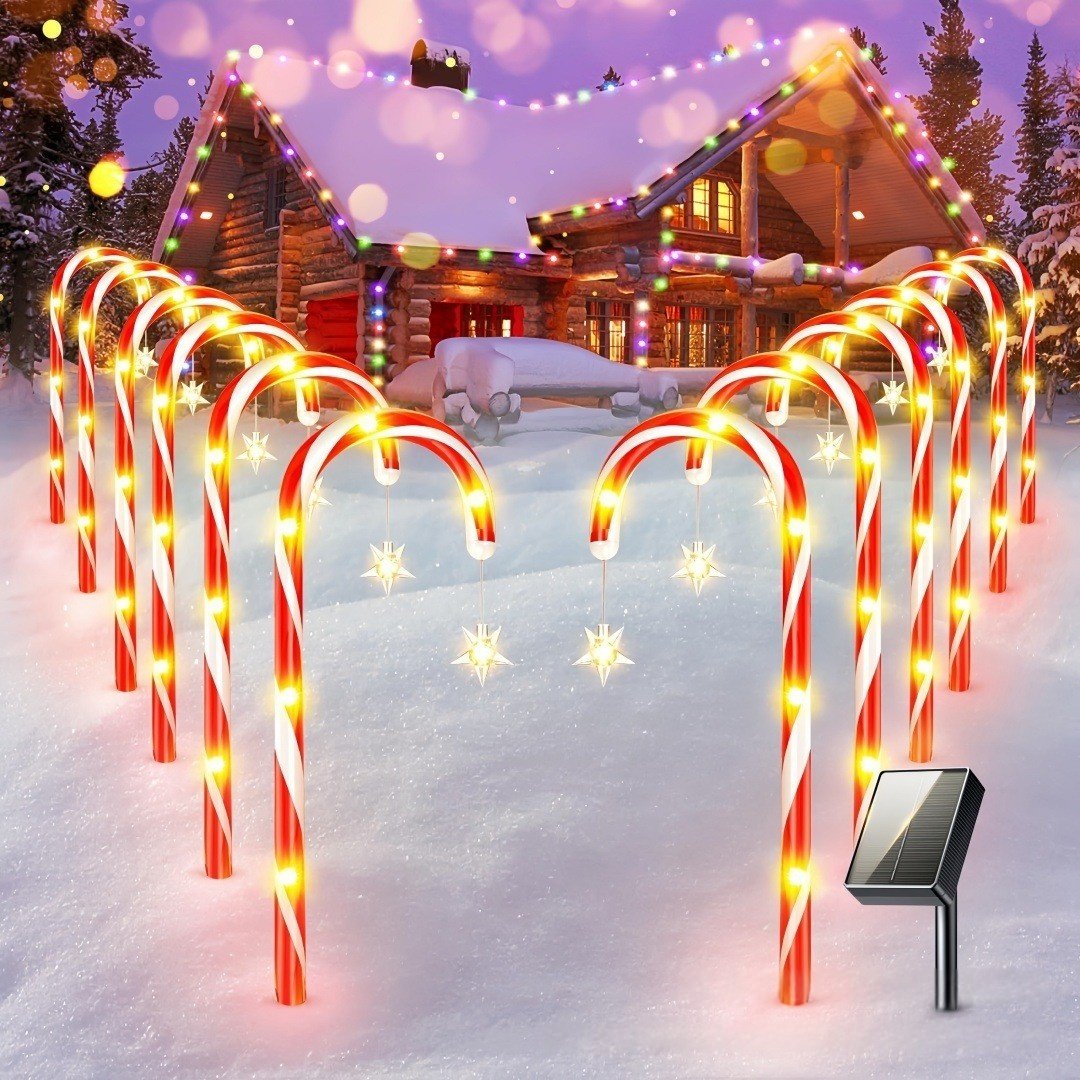 A set of candy cane lights glowing in front of a snowy cabin