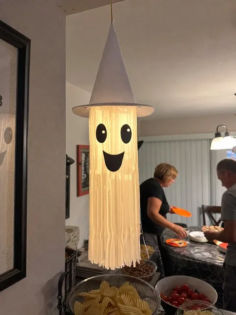 White light-up tassel ghost near a casual Halloween party table