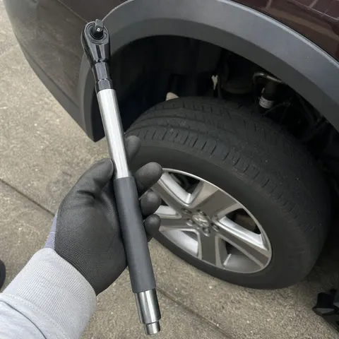 Customer holding the offset ratchet extension by a wheel well