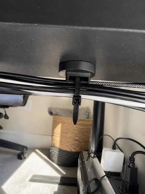 Customer-style photo of desk cables held beneath a steel surface