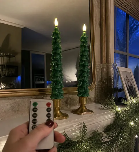 Customer-style photo of two tree candles on a mantel